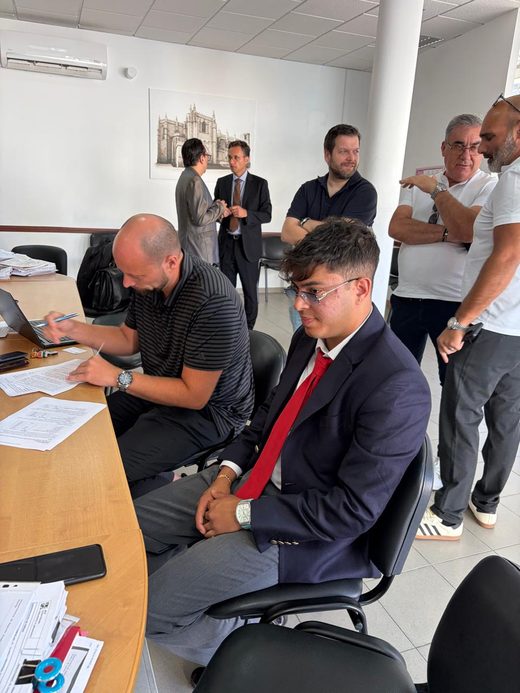 Jai Agarwal at a desk covered in documents while the Guarda FC papers are signed